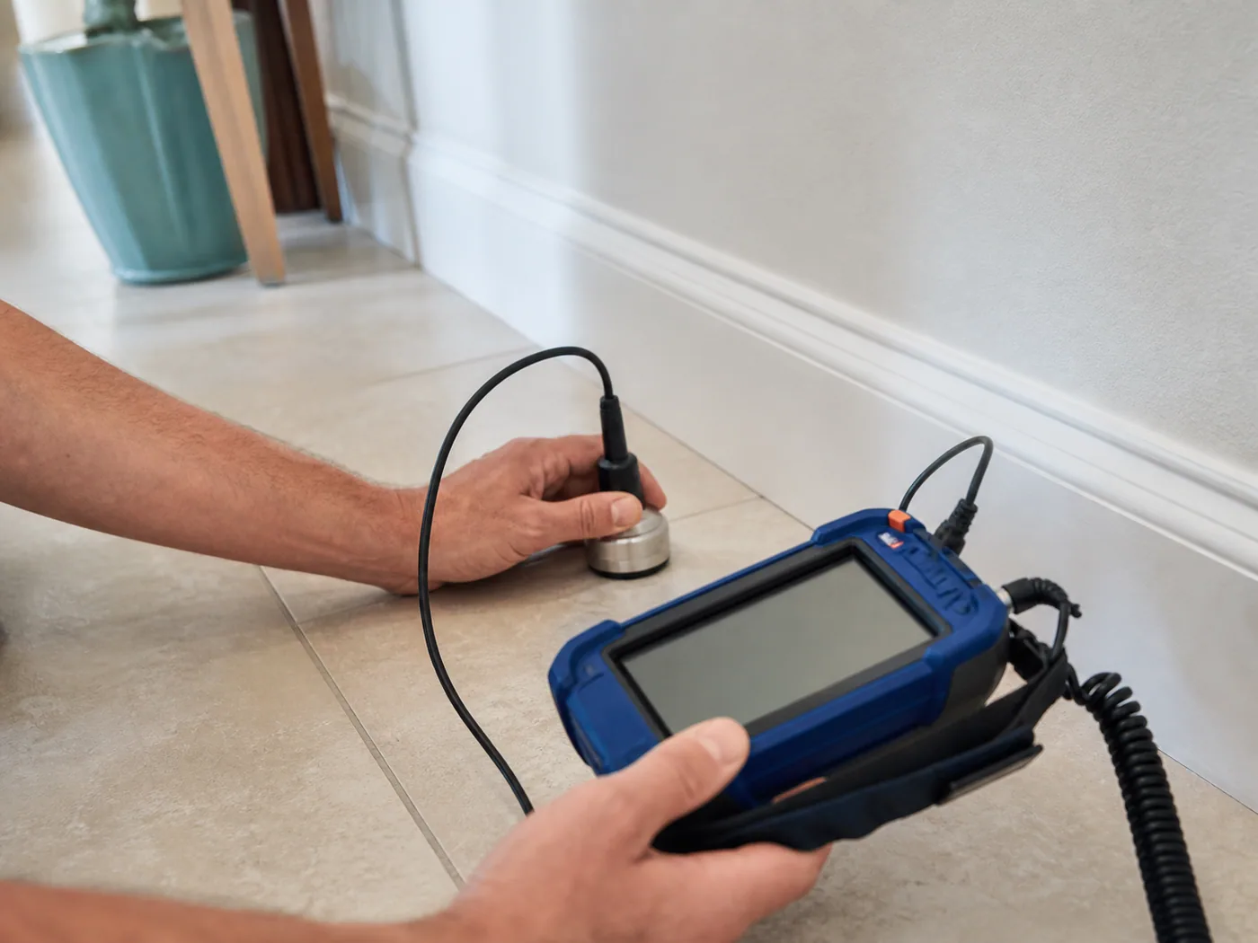 Acoustic equipment checking a tiled floor for a suspected slab leak